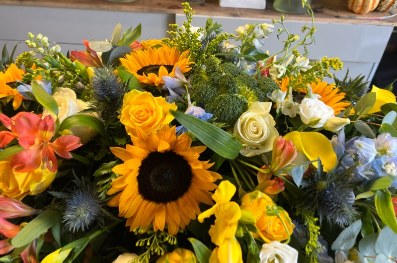 Sunflower and blue delphinium casket spray