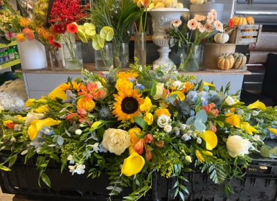 Sunflower and blue delphinium casket spray